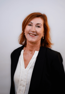 Porträtfoto eines weiblichen Teammitglieds mit rötlichem Haar.